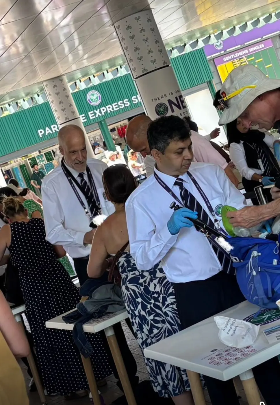 Security officers checking a guest's bag at an event entrance