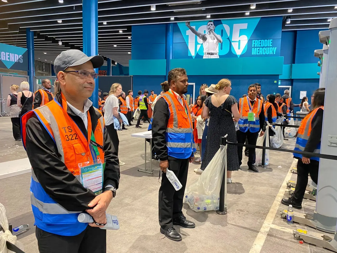 Stewards and guests in a busy concourse during entry searches